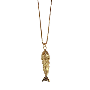 Gold fish-shaped pendant on a chain against a white background